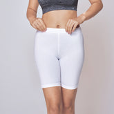 Woman wearing a grey sports bra and Cycling Shorts for Women on a light grey background