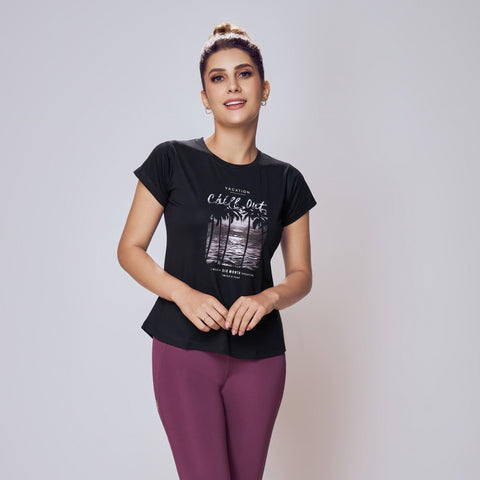 Woman wearing a black t-shirt and purple leggings against a plain background