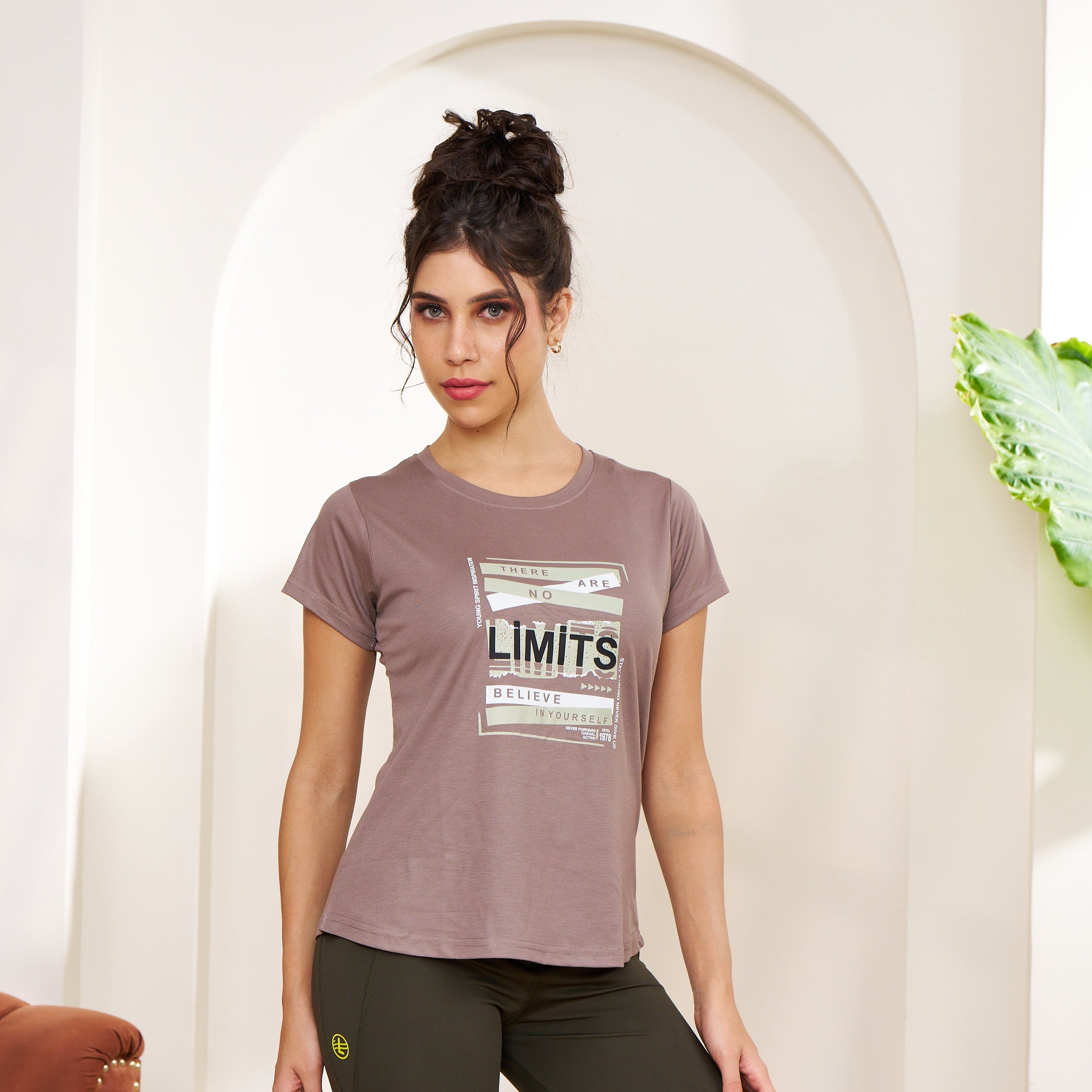 Woman wearing a t-shirt with text design in a minimalistic setting
