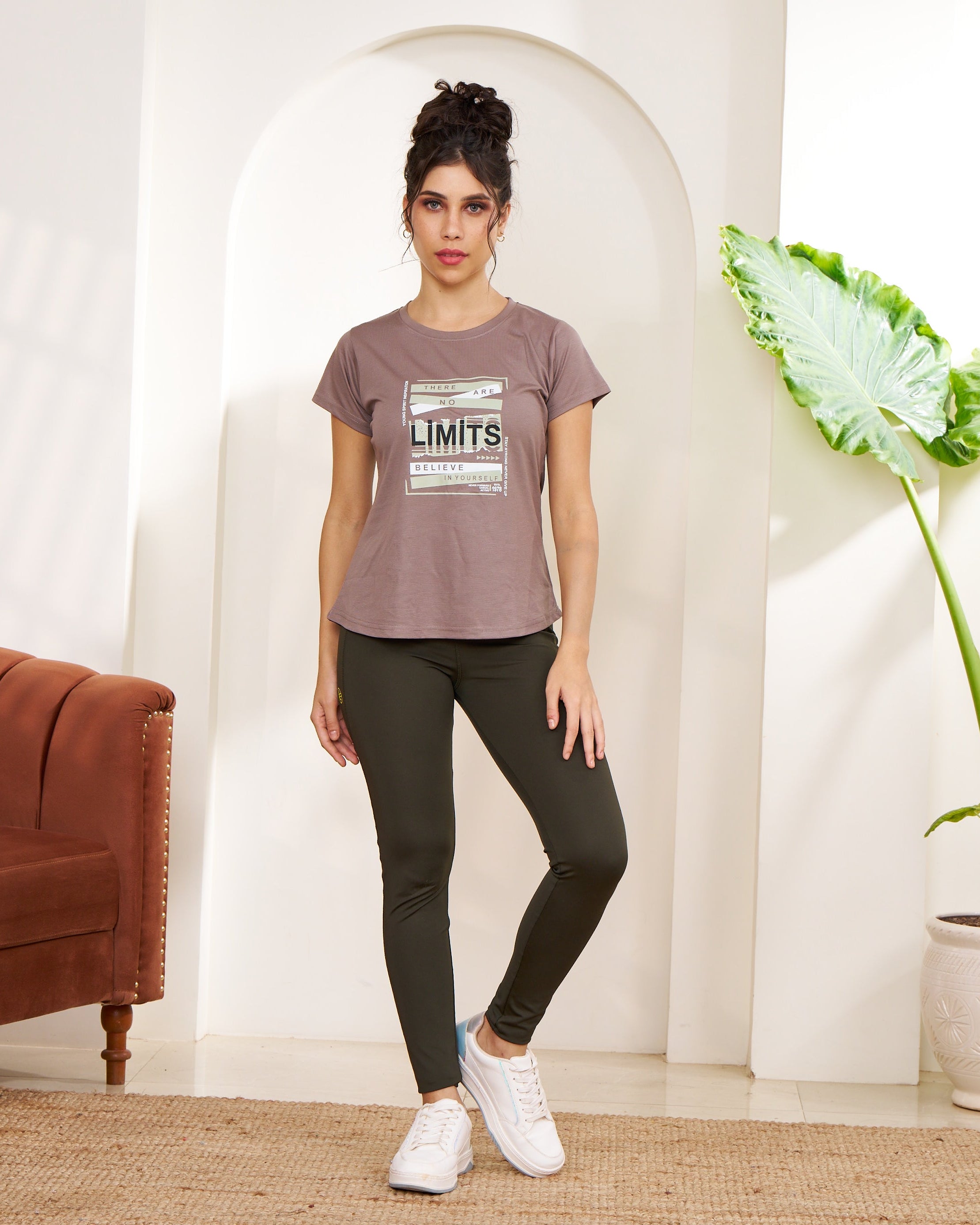 Woman standing in a room with a plant and a couch