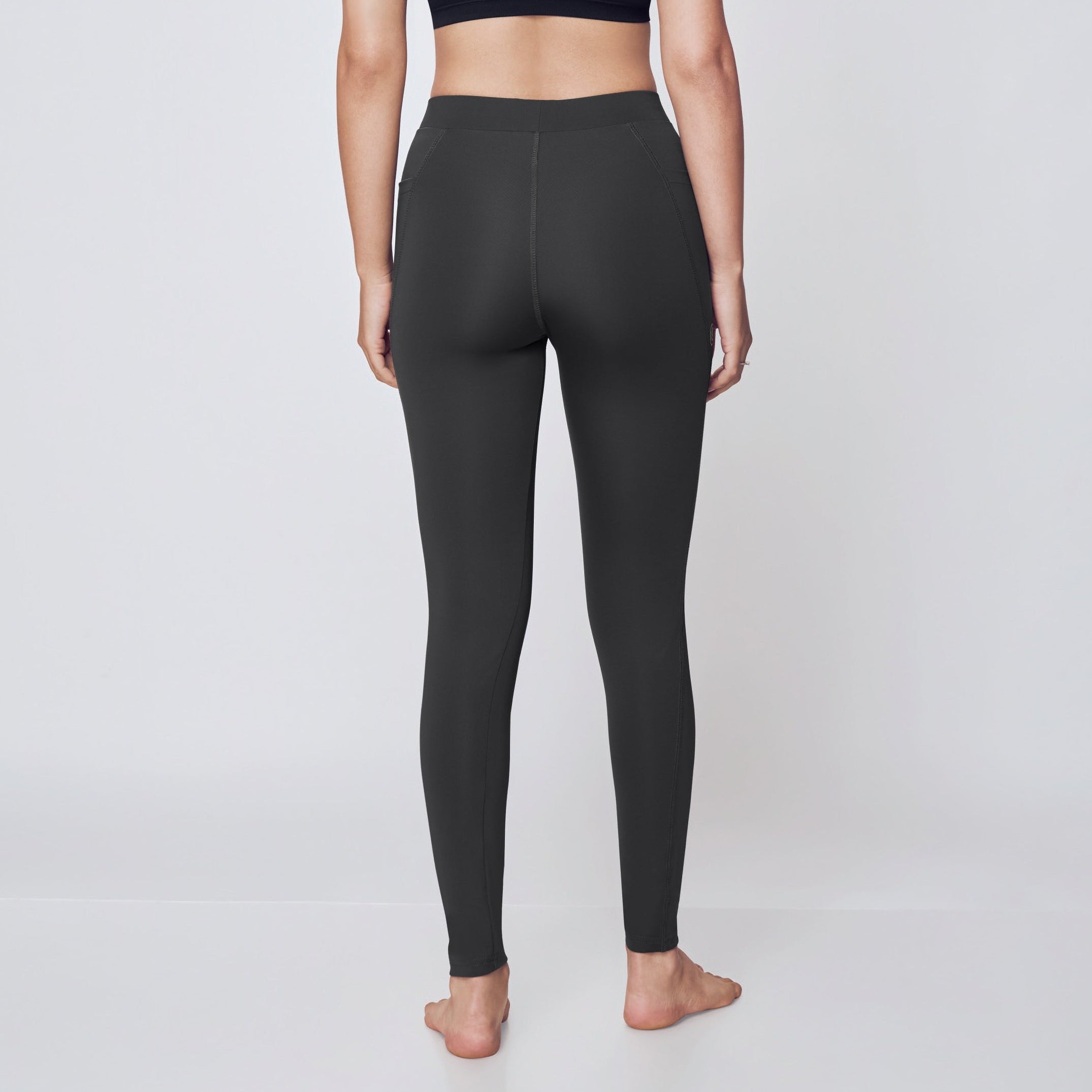 Person wearing black athletic bra and leggings on a white background