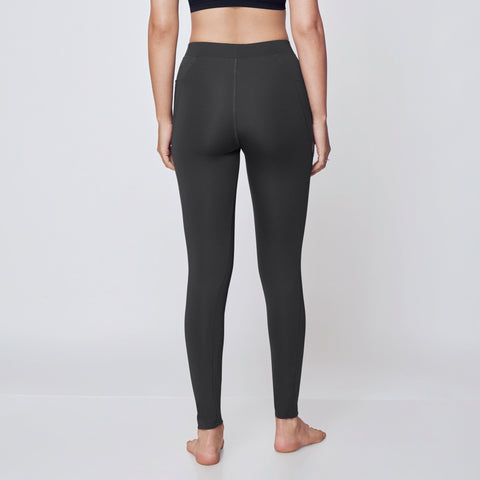 Person wearing black athletic bra and leggings on a white background