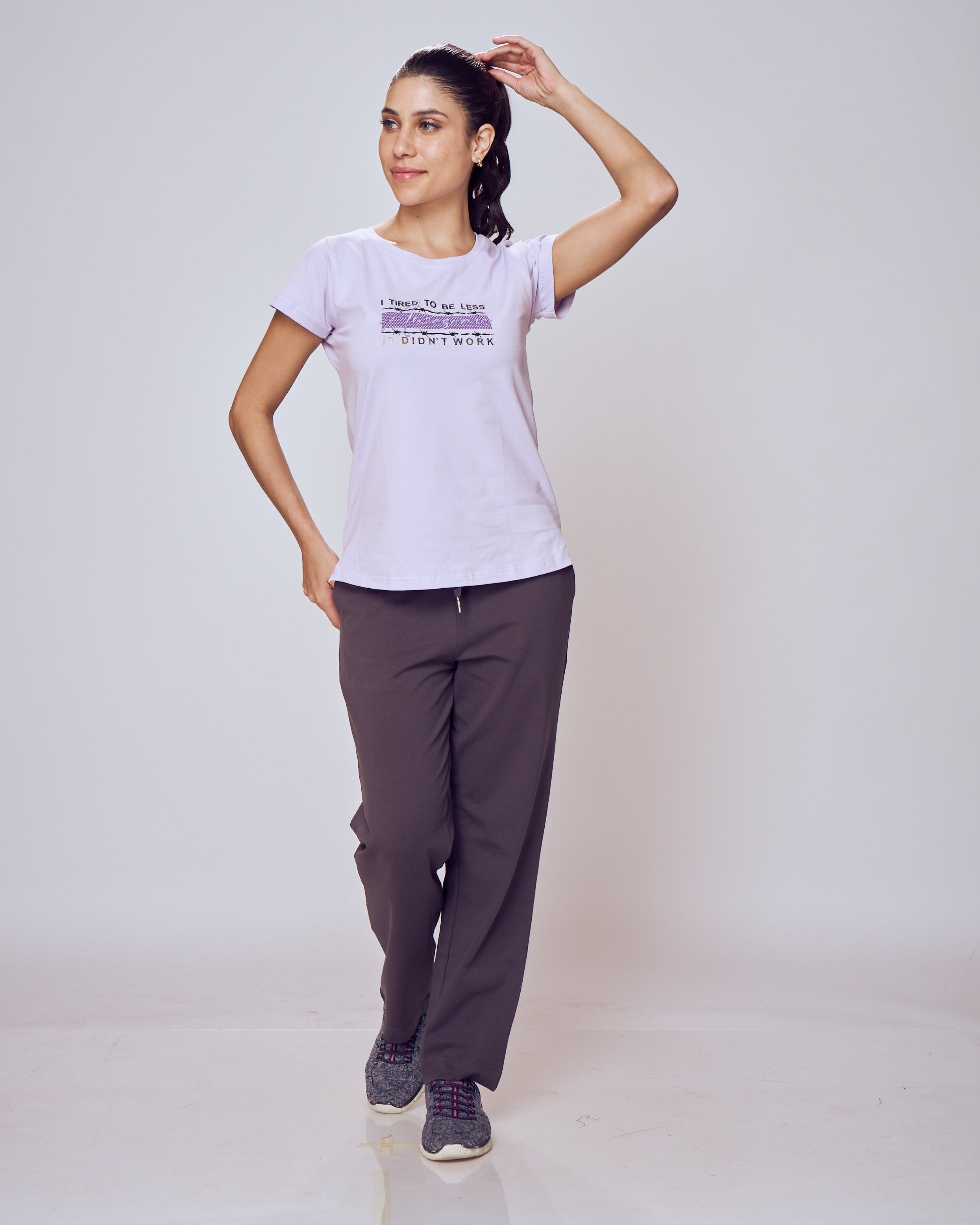 Woman wearing a white t-shirt and gray Classic Flex Regular Fit Track Pants on a plain background