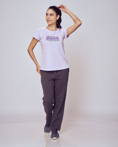 Woman wearing a white t-shirt and gray Classic Flex Regular Fit Track Pants on a plain background