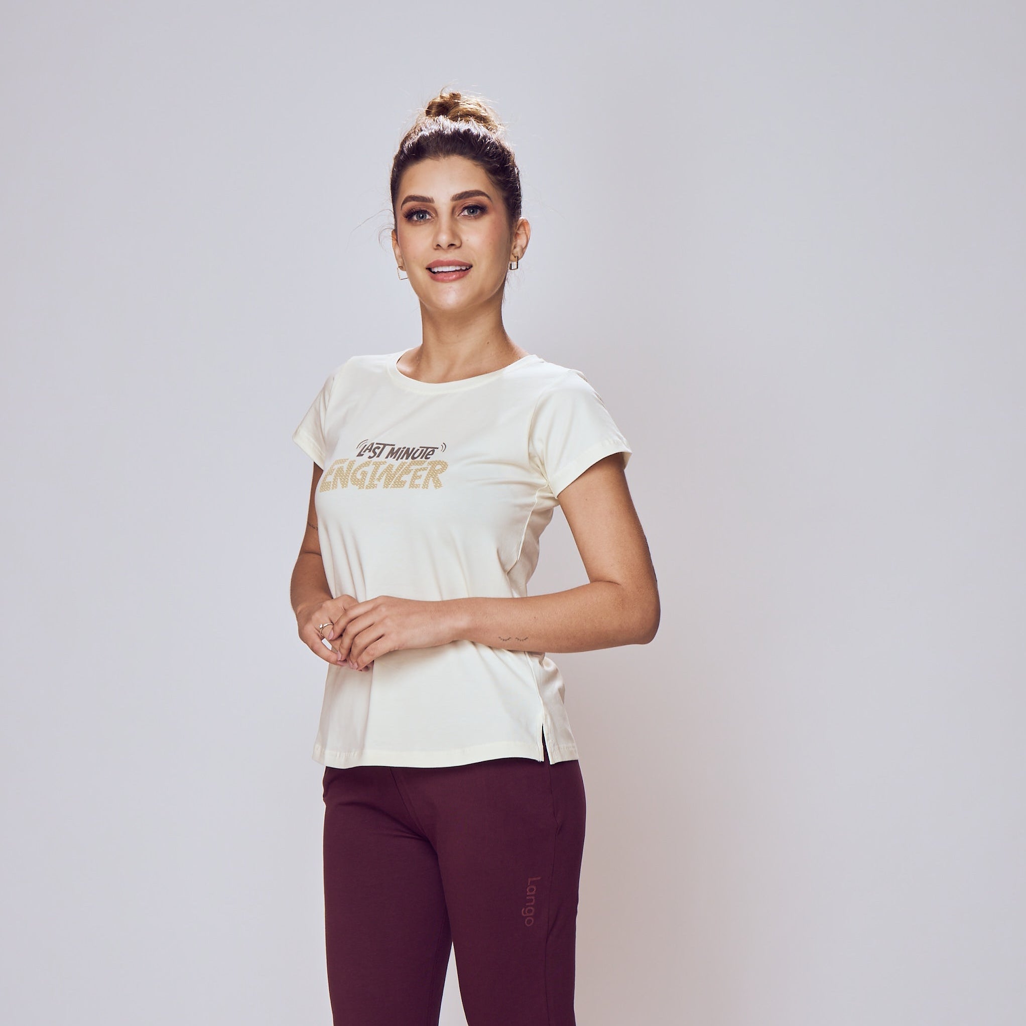 Person wearing a white t-shirt and maroon pants on a plain background