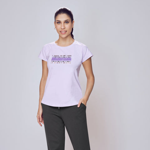 Person wearing a white t-shirt with text and dark pants on a plain background