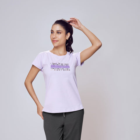 Woman wearing a white t-shirt with text and dark pants on a light gray background