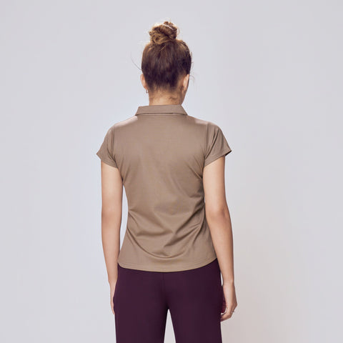 Person wearing a beige shirt and dark purple pants on a white background