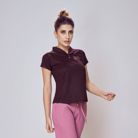Woman wearing a dark polo shirt and pink pants on a white background