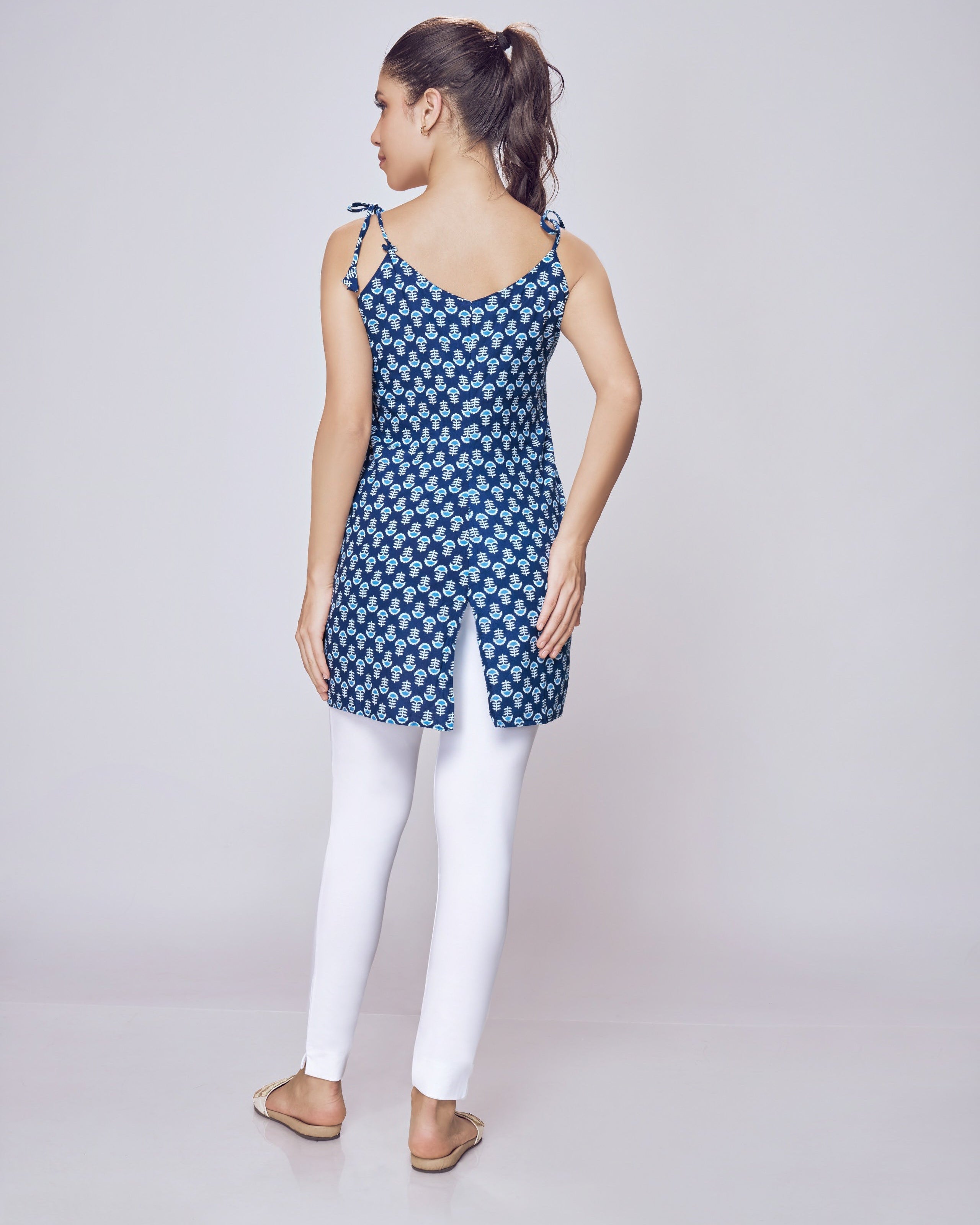 Woman wearing a blue patterned top and white Kurti Pants Leggings on a gray background