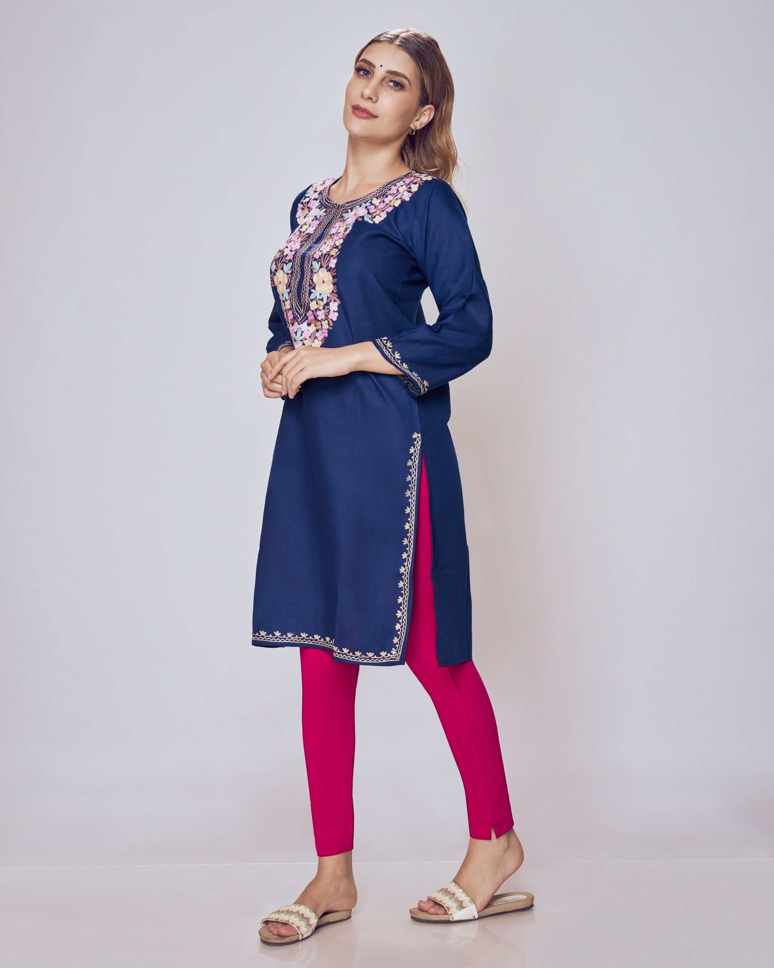 Woman wearing a navy blue kurta with pink pants on a white background