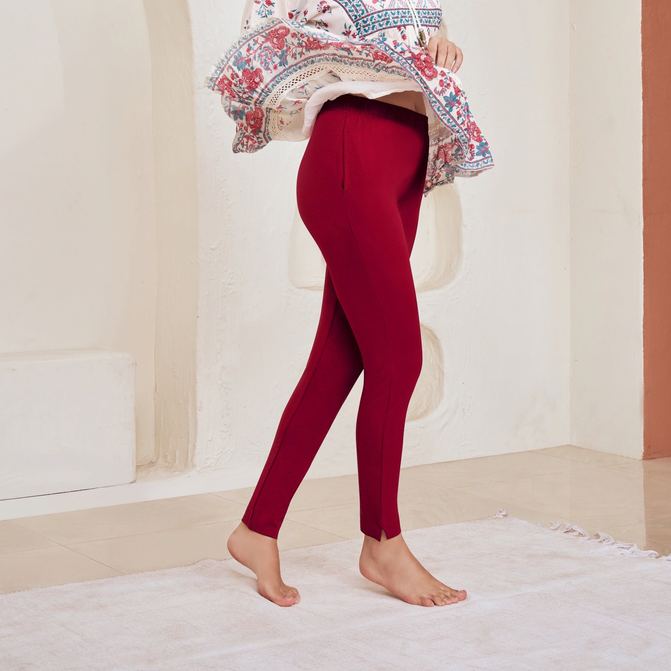 Woman wearing a colorful top and red Kurti Pants Leggings in a modern interior setting