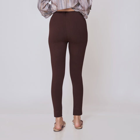 Woman wearing a striped shirt and brown pants on a white background