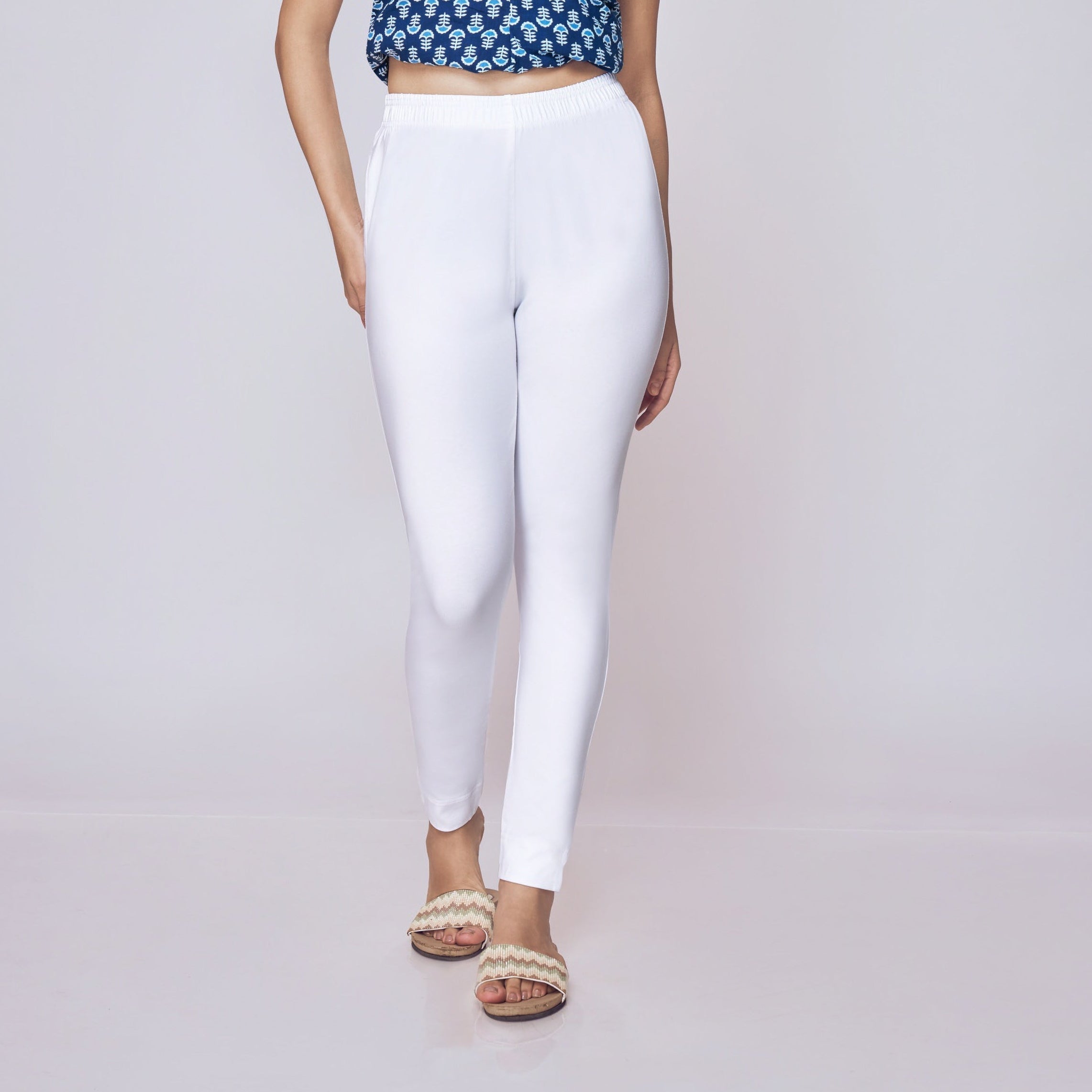 Woman wearing a blue patterned top and white Kurti Pants Leggings on a gray background