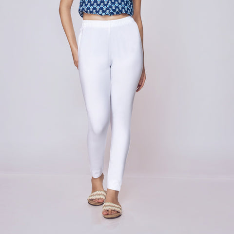 Woman wearing a blue patterned top and white Kurti Pants Leggings on a gray background