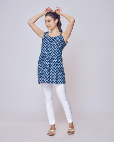 Woman wearing a blue patterned top and white Kurti Pants Leggings on a light gray background