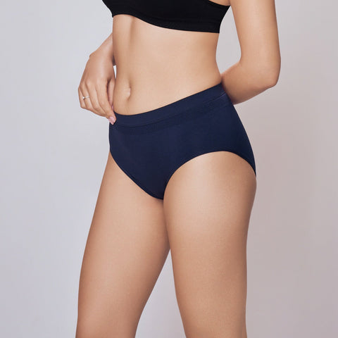 Woman wearing a black sports bra and navy Lady Care Air V Hipster Panty on a gray background