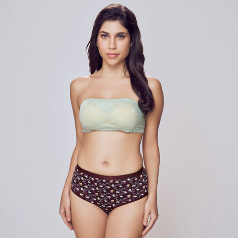 Woman wearing a light green strapless top and patterned brown underwear on a gray background