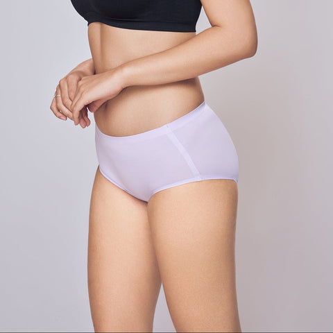Woman wearing a black bra and Lavander Lady Care Think Hipster Panty on a plain background