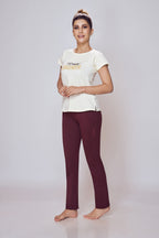 Woman wearing a white t-shirt with text and maroon leggings on a light gray background
