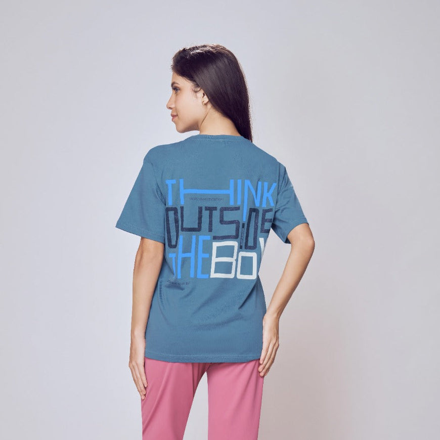 Person wearing a blue t-shirt with text on the back and pink pants against a white background