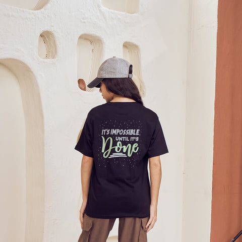 Person wearing a black t-shirt with text in a modern indoor setting