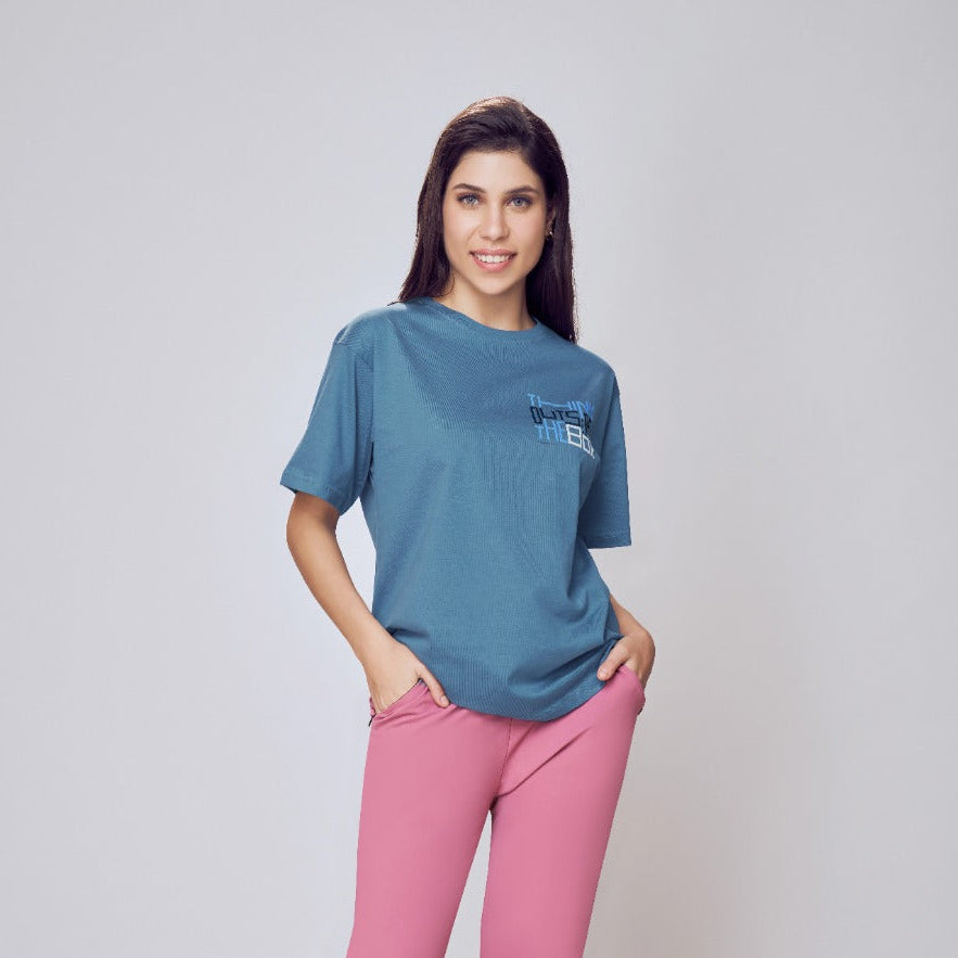 Woman wearing a blue t-shirt and pink pants on a white background