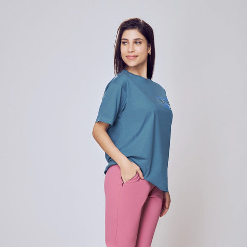 Woman wearing a blue shirt and pink pants on a white background