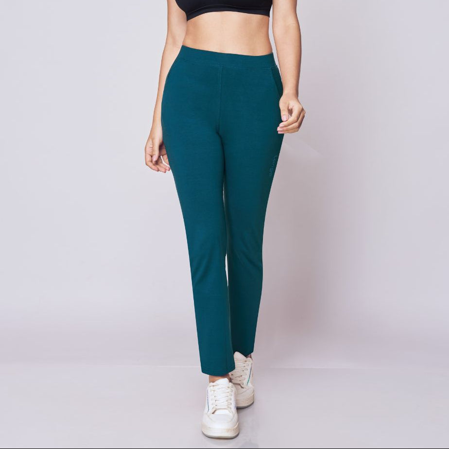 Woman wearing a black sports bra and Peacock Blue Power Move Track Pants on a white background