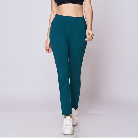 Woman wearing a black sports bra and Peacock Blue Power Move Track Pants on a white background