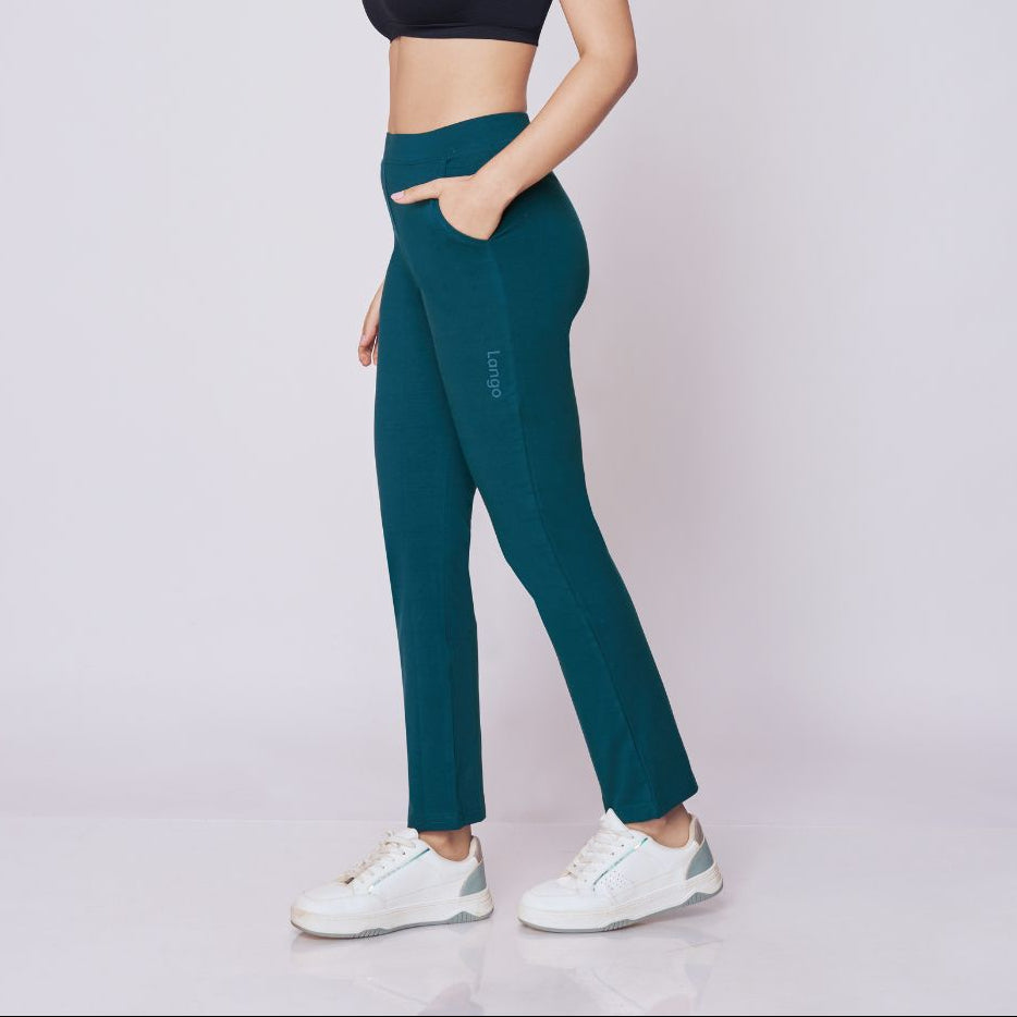 Woman wearing a black sports bra and maroon  Power Move Track Pants on a white background 