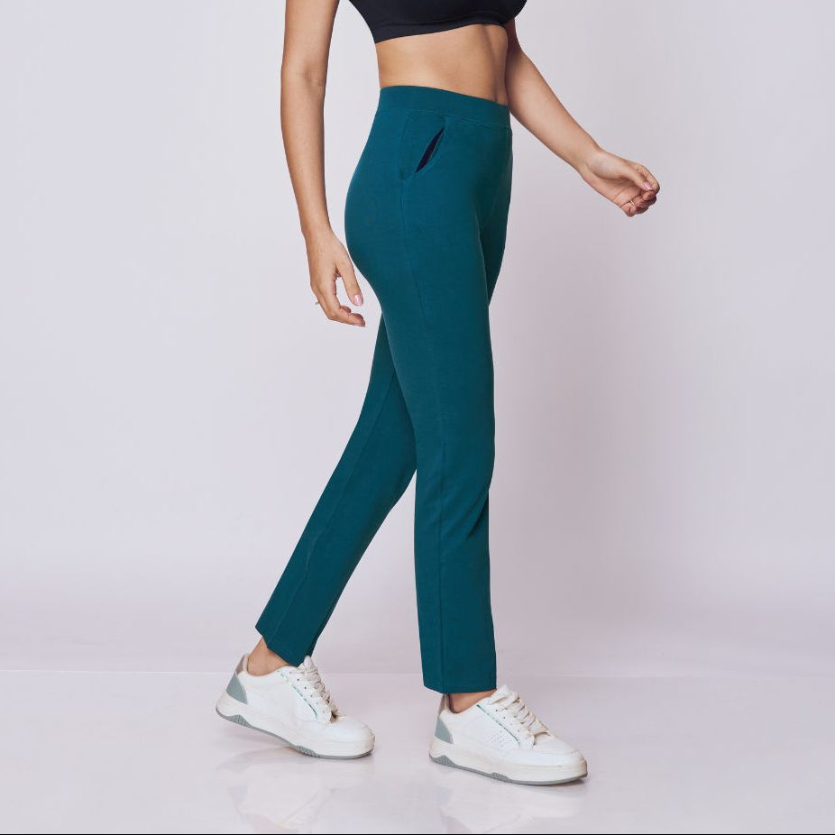 Woman wearing a black sports bra and maroon  Power Move Track Pants on a white background 