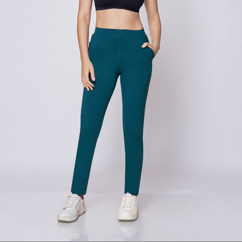 Woman wearing a black sports bra and maroon  Power Move Track Pants on a white background 