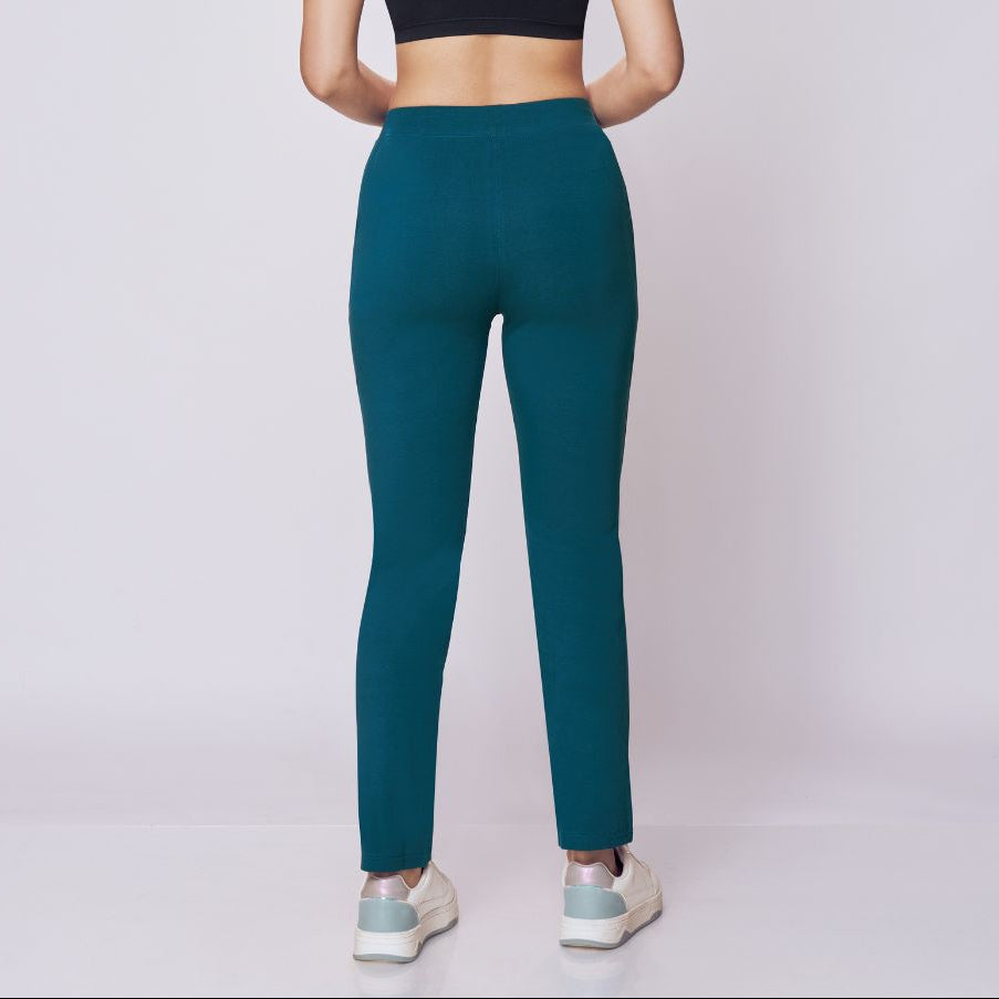 Woman wearing a black sports bra and maroon  Power Move Track Pants on a white background 