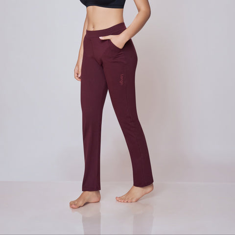 Woman wearing a black sports bra and maroon Power Move Track Pants on a white background