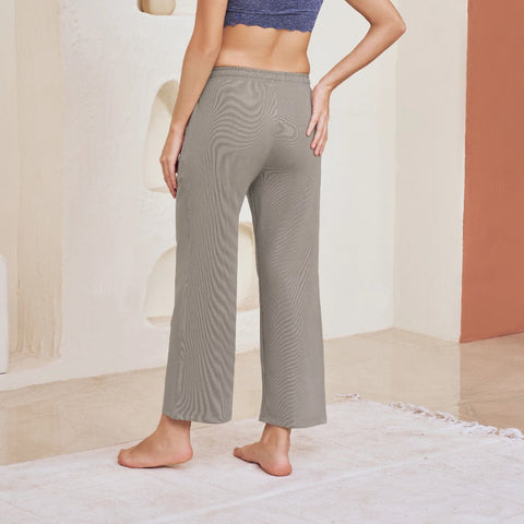Woman in a blue sports bra and gray Regular fit Ankle length Track Pant  standing in a modern, minimalistic room.