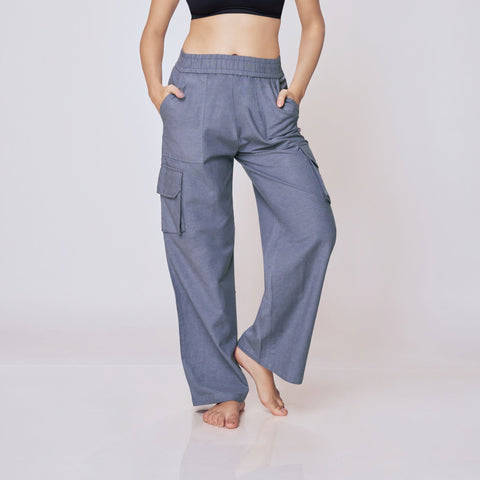 Woman wearing a black sports bra and gray cargo pants on a white background