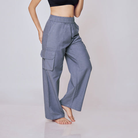 Woman wearing a black sports bra and gray cargo pants on a white background