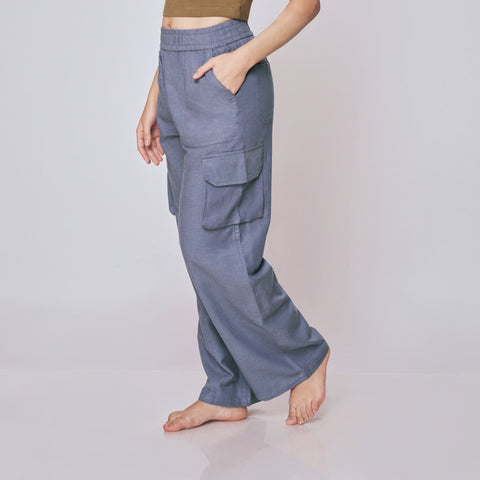 Woman wearing a brown top and gray cargo pants on a white background