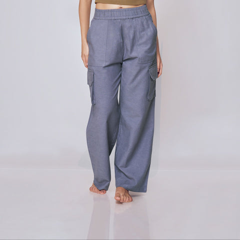 Woman wearing a green crop top and gray pants on a white background